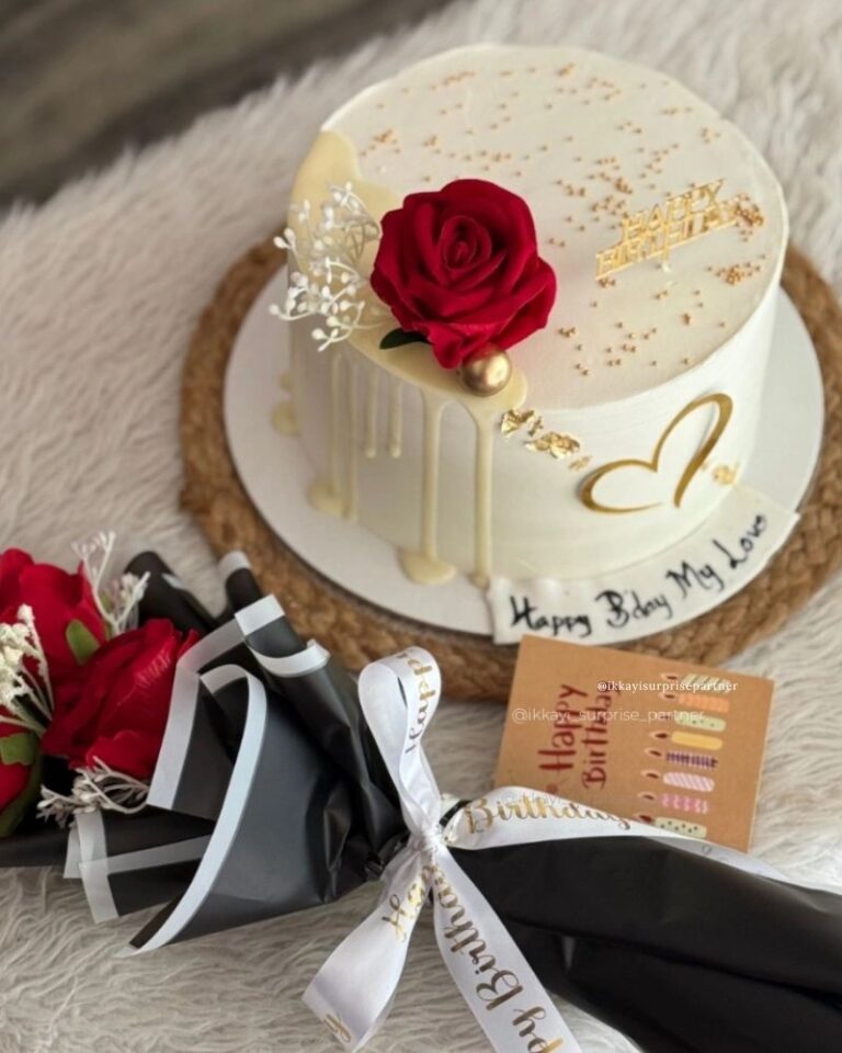 White birthday cake with red rose, gold heart, and a matching red rose bouquet gift set.