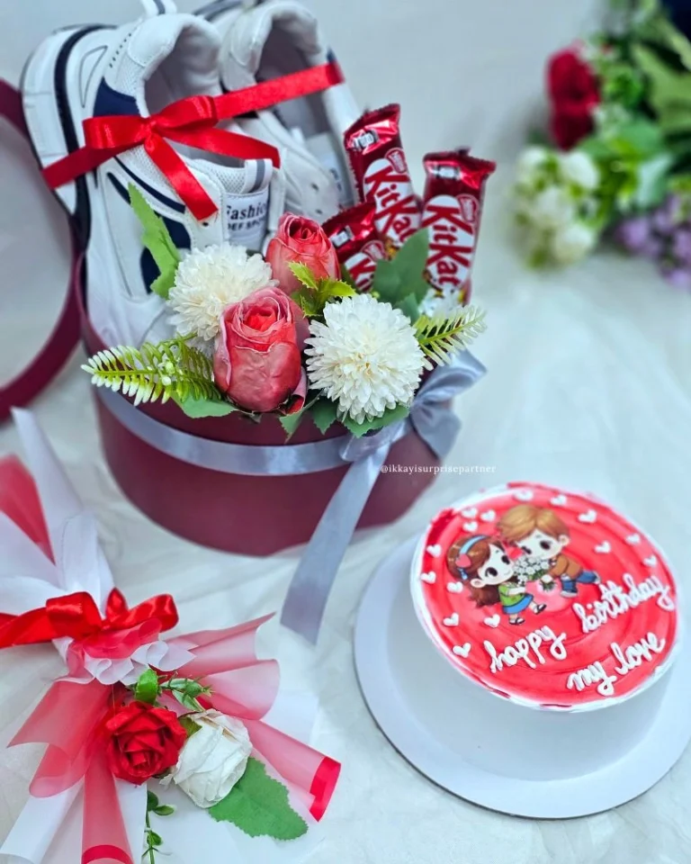 Cartoon couple cake, red gift box with white sneakers, and KitKat chocolates.