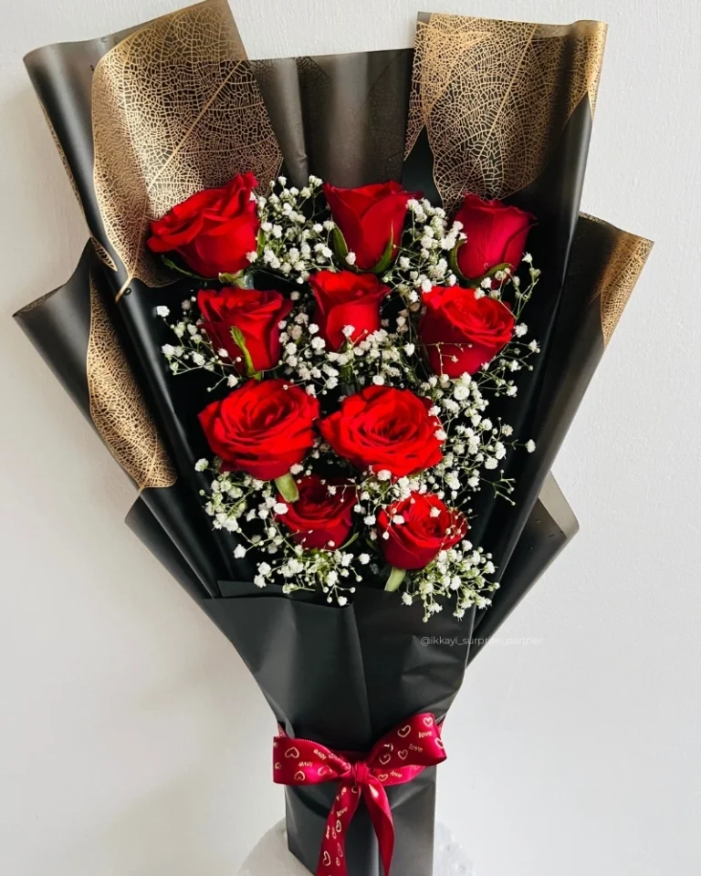 Nine red rose bouquet wrapped in black and gold paper with baby's breath.