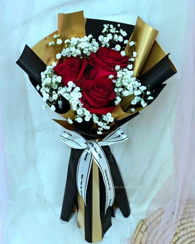 Three red rose bouquet with baby's breath, wrapped in black and gold paper.
